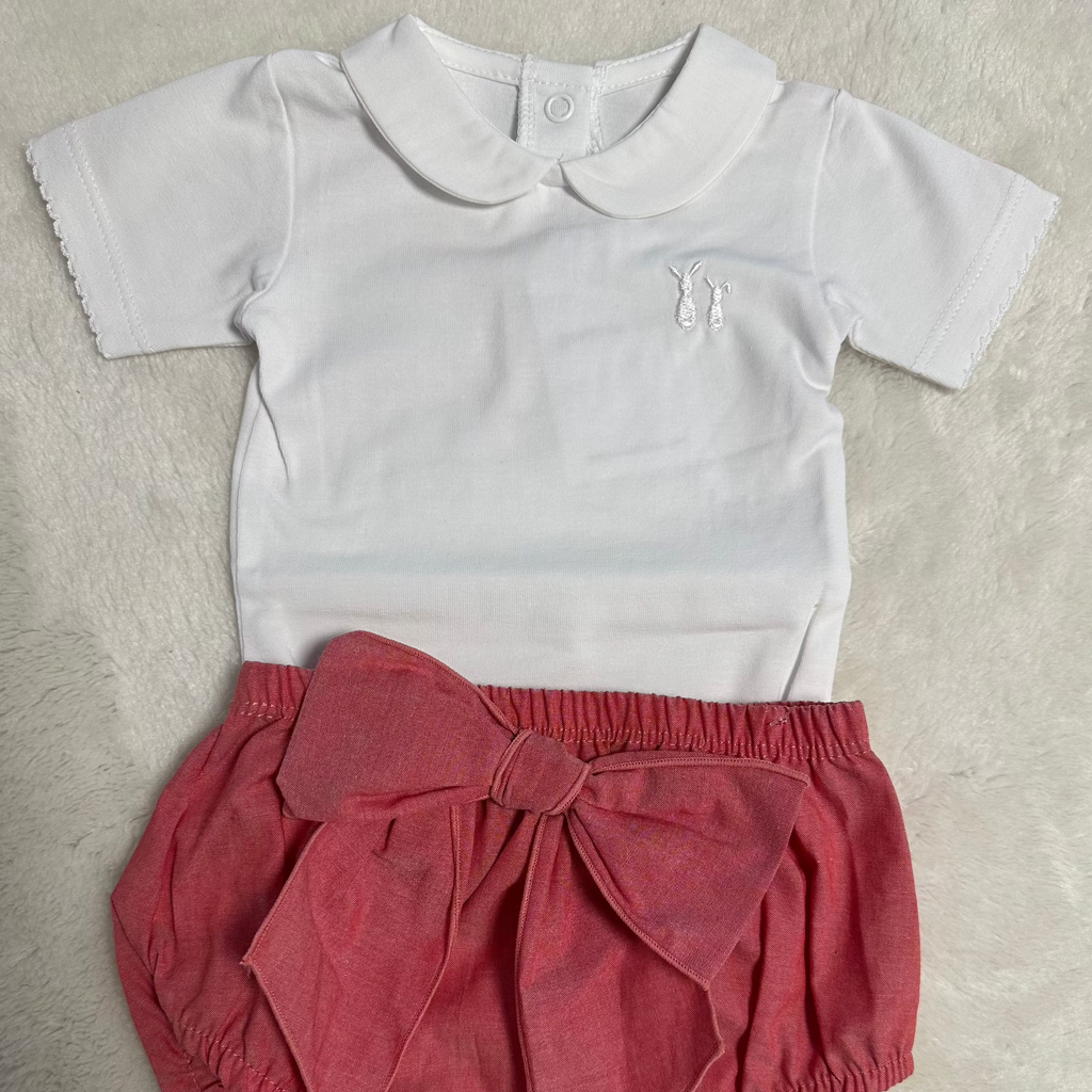 Een witte baby romper en een roze bloomer met strik