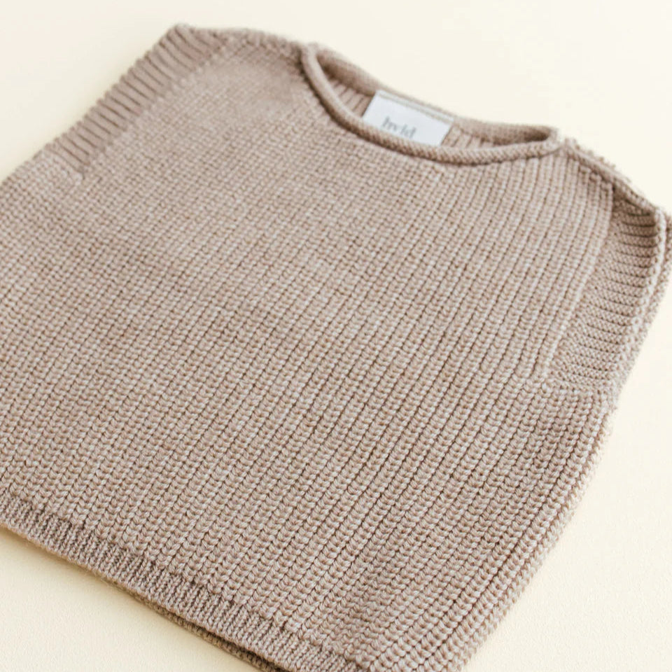 Een beige baby vestje mouwloos